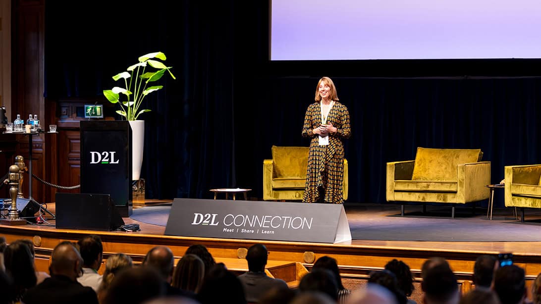 Woman presenting on stage at D2L Connection event