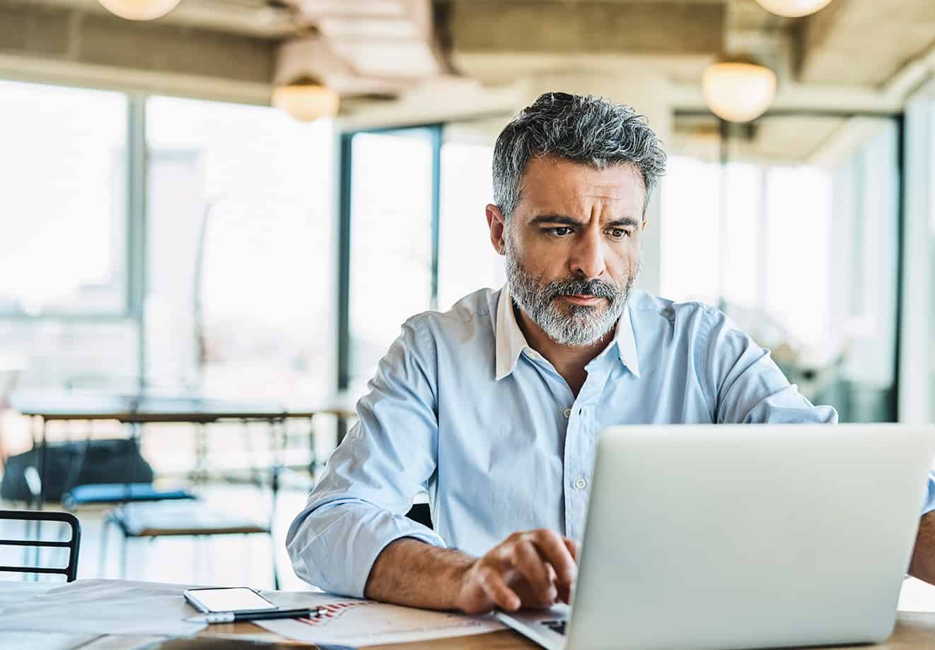 Man focused on work while typing on laptop