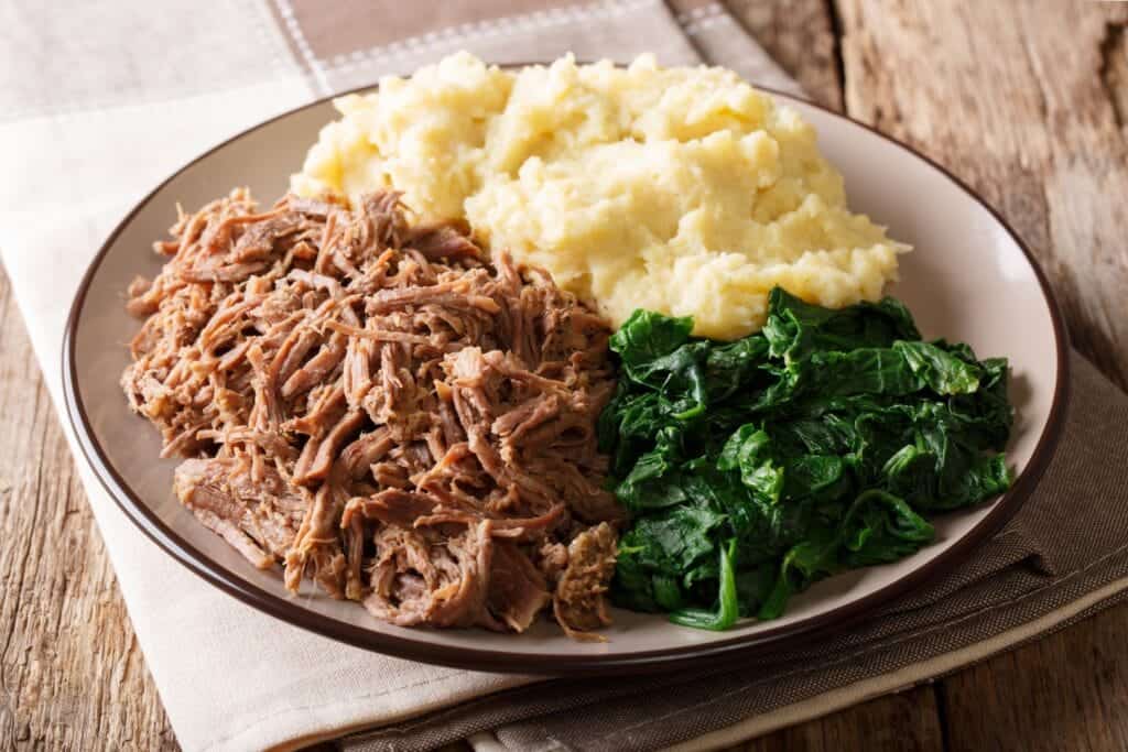 A close-up of a plate of stewed beef with Sadza and spinach. Photo: Getty Images