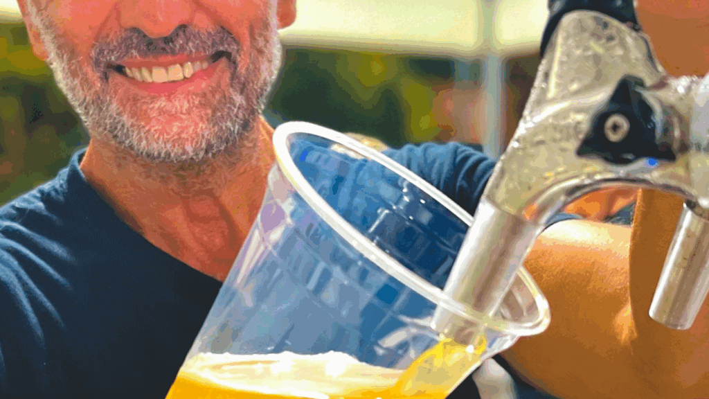 Gobelet compostable transparent rempli de bière lors d’un événement.