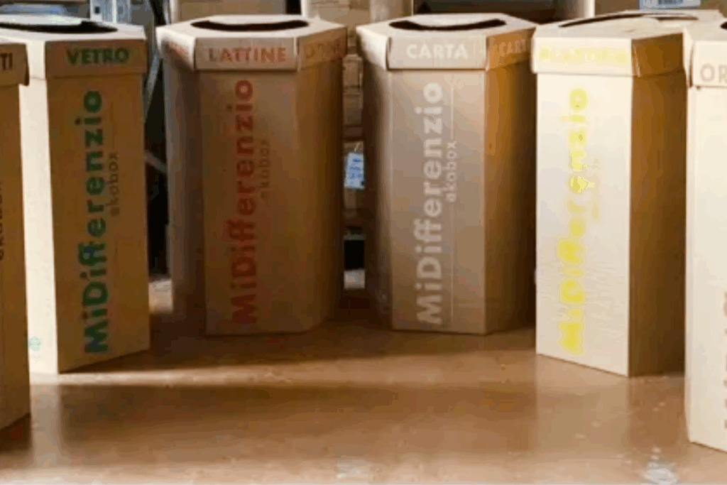 Contenitori in cartone per la raccolta differenziata di vetro, plastica, carta, organico e lattine durante eventi pubblici.