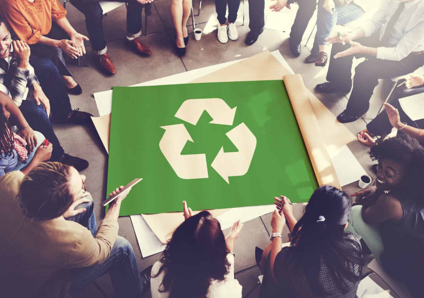 des personnes sont regroupées autour d'une image de recyclage