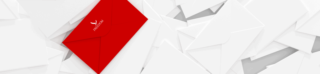 Table full of white envelopes, and one red envelope on top with the Freedom logo on the flap.