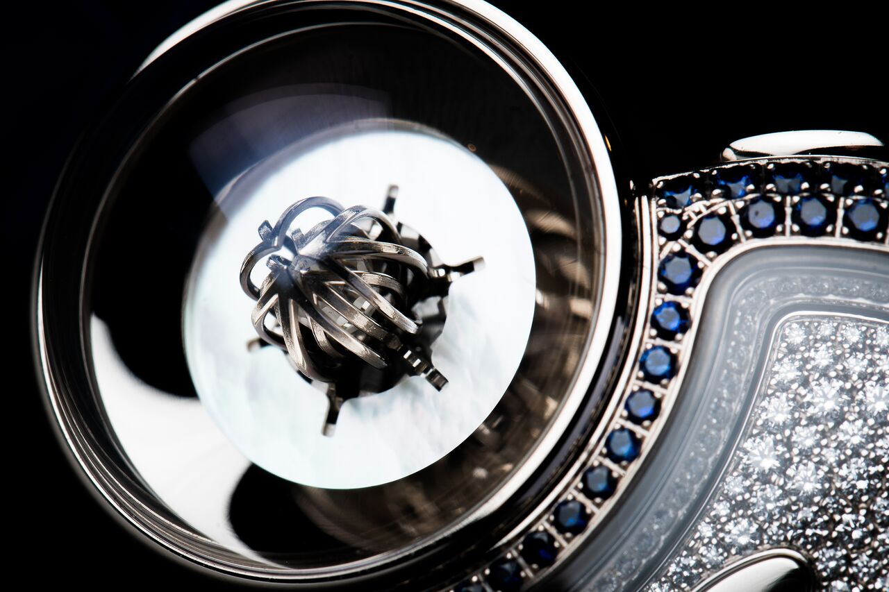 Skeletonized white gold flower petals cover the Briolette diamond at its center