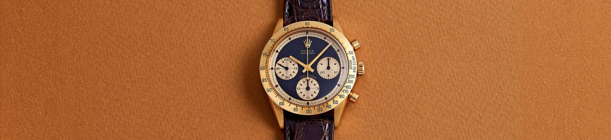 Rolex Cosmograph Daytona chronograph in yellow gold with a black dial and gold subdials, on a brown leather strap