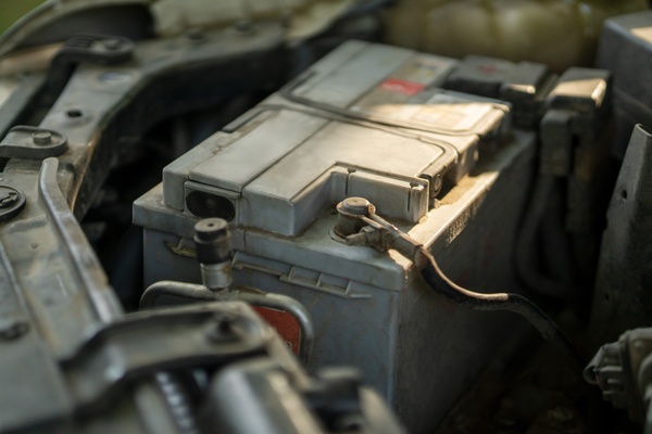 Sunlight shining on a gray battery inside a dusty truck hood. The ...