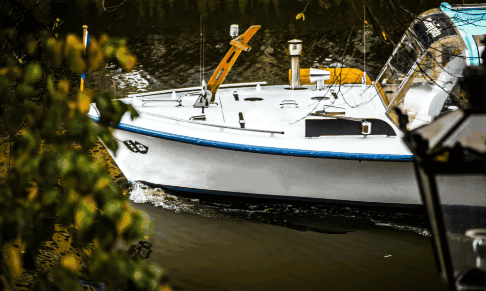 A boat on a canal in Amsterdam. The boat is floating on the water.