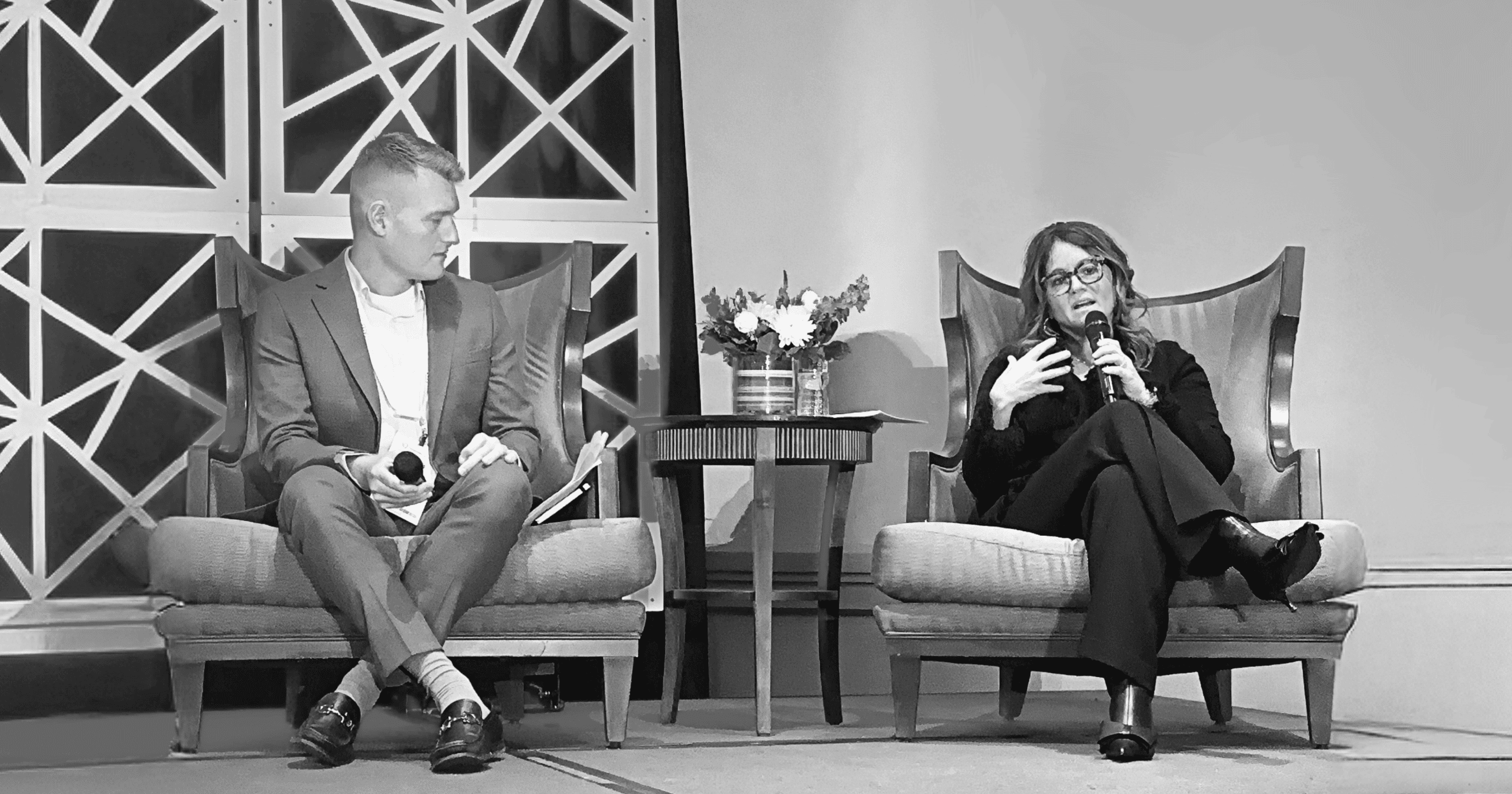 A black-and-white photo of Joshua Feazell of Infinitus and Michele Angelaccio of Novartis on stage in November 2025.