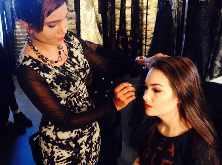 Makeup training grad hard at work backstage at a fashion show