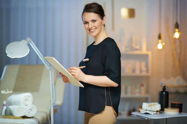 A spa therapist holding a clipboard.