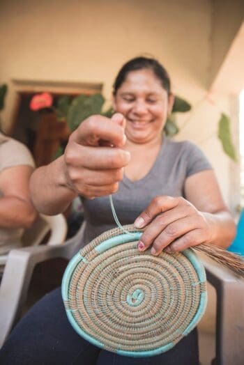 Picture of happy lady weaving bowl