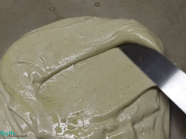 Biskuitmasse wird vorsichtig am Backblech mit einer Palette verstrichen.