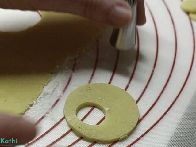 Mit Hilfe einer Tülle bei jedem zweiten Keks ein weiteres Loch ausstechen.