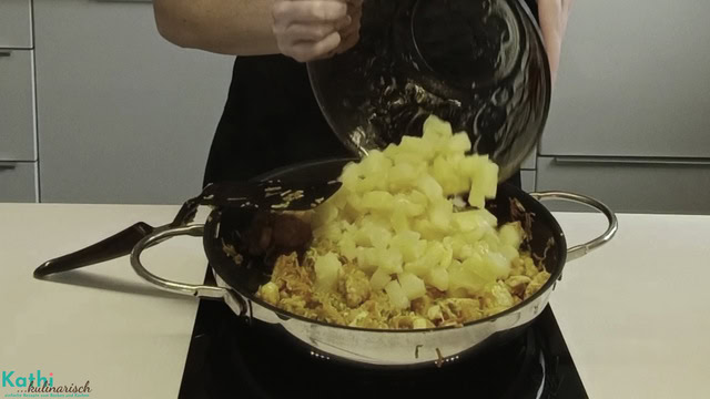 Ananasstücke werden zum Fleisch und dem Gemüse hinzugefügt.
