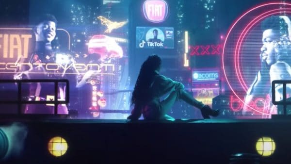 An image from Lil Nas X's 'Panini music video. A woman in the foreground is facing away from the camera, looking towards a futuristic cityscape full of large holographic advertisements featuring Lil Nas X