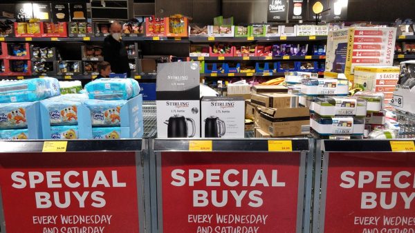a display table in an Aldi supermarket, stocked with nappies, electric kettles, kitchenware and other assorted items in boxes. A sign at the bottom of the display table says "Special Buys: Every Wednesday and Saturday"