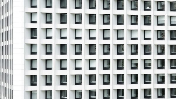 an exterior view of a block of identical-looking small apartments in a gleaming white building