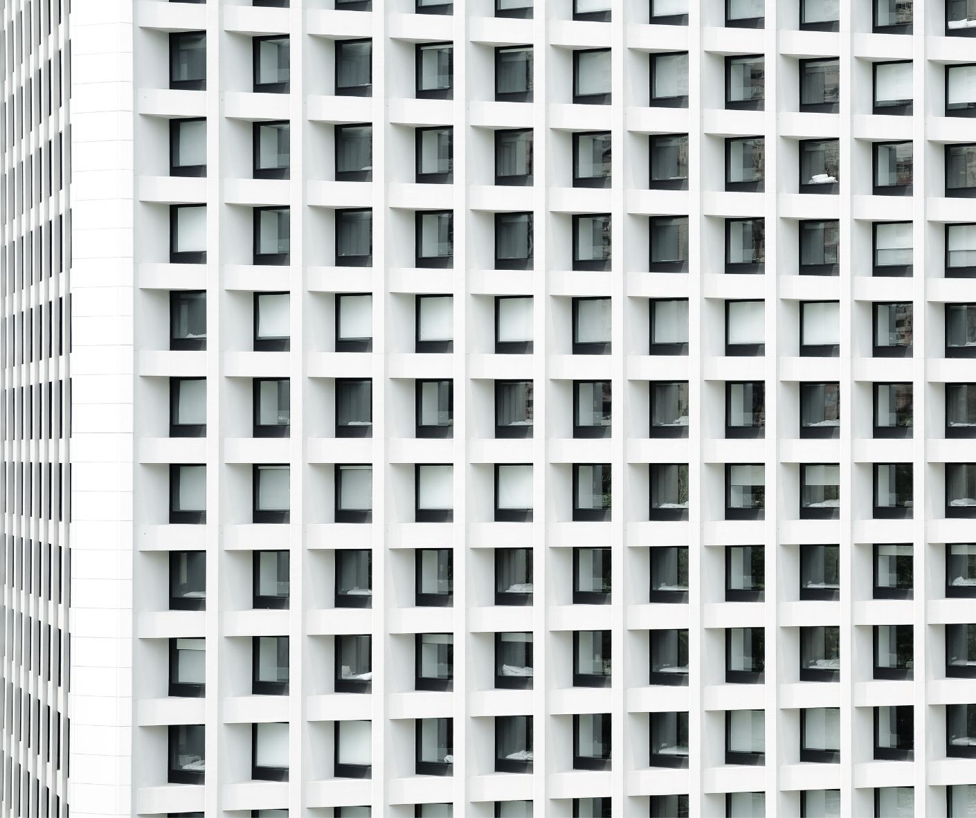 an exterior view of a block of identical-looking small apartments in a gleaming white building