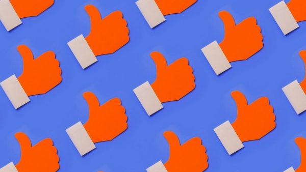 A pattern of red 'like' thumbs up hand symbols, on a blue background