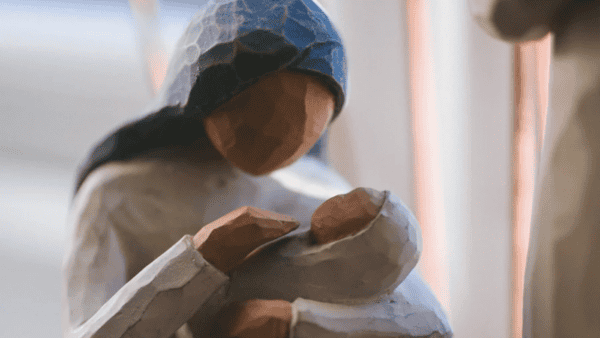Wooden carving of mother cradling baby.
