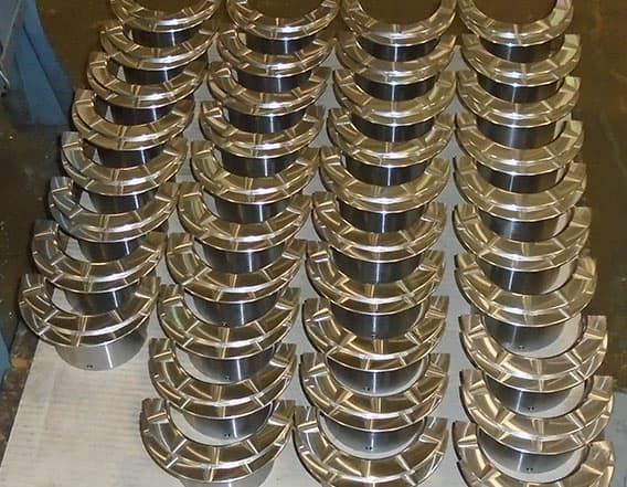 Pallet of thirty-eight 4x3 Thrust Bearing halves, aligned with their mating half.
