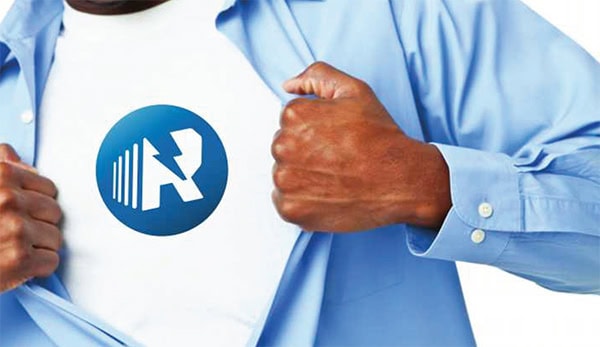 Close up of a man's chest, ripping his dress shirt open in the style of Superman, to reveal his tee shirt emblazoned with the Rapid Response logo.