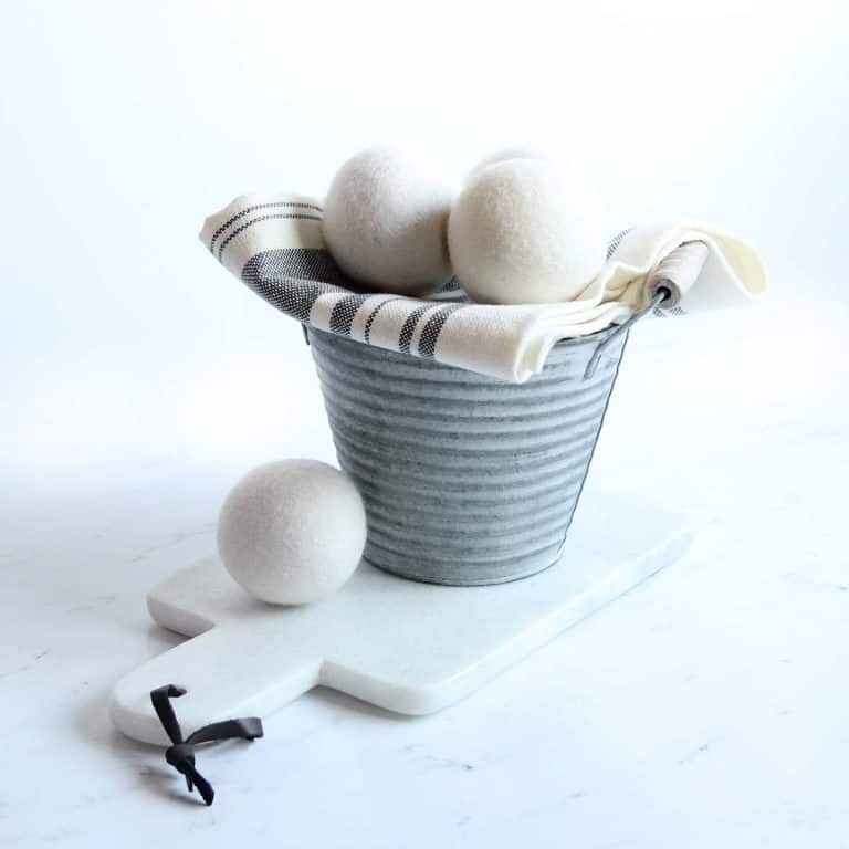 metal laundry bucket with cleaning cloths and wool dryer balls
