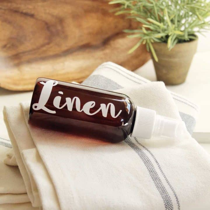 amber bottle labeled linen on a stack of linen towels
