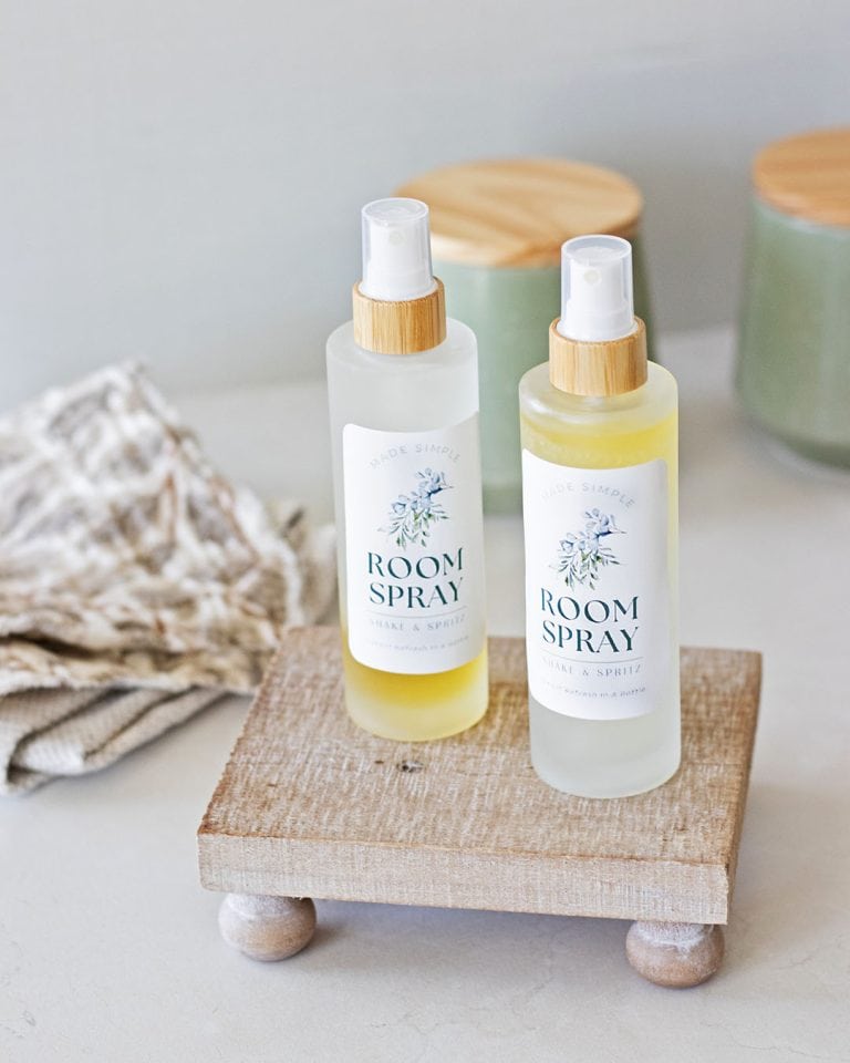 two bottles of room spray with DIY labels on a wood tray