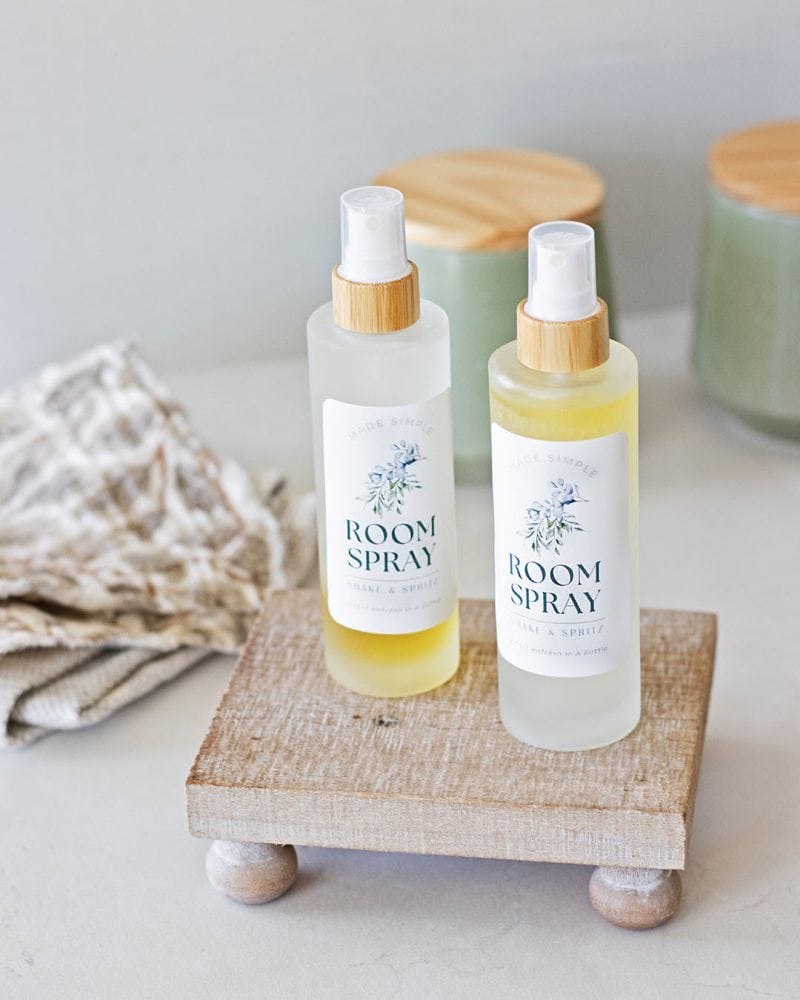 two bottles of room spray with DIY labels on a wood tray