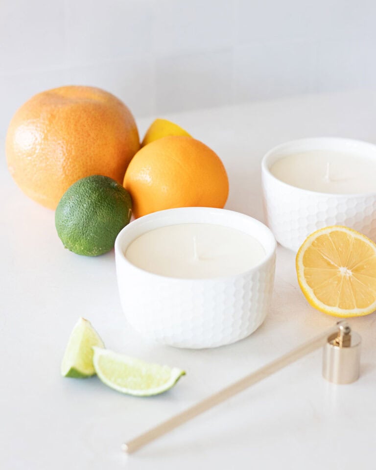 citrus candles in white ramekins among colorful fresh citrus fruits