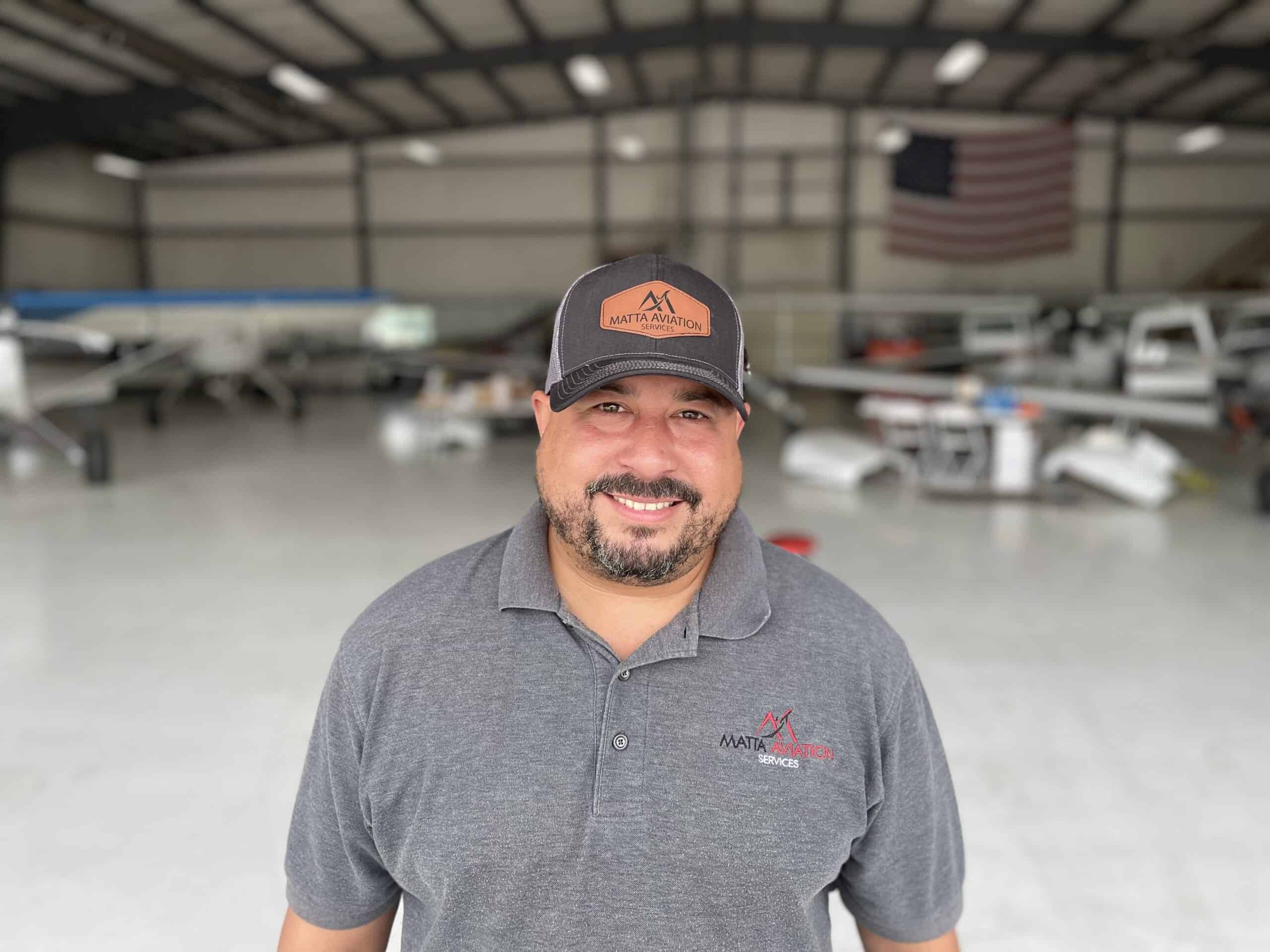 Aircraft maintenance technician in a hangar with small aircraft FAA A&P Prep Course.