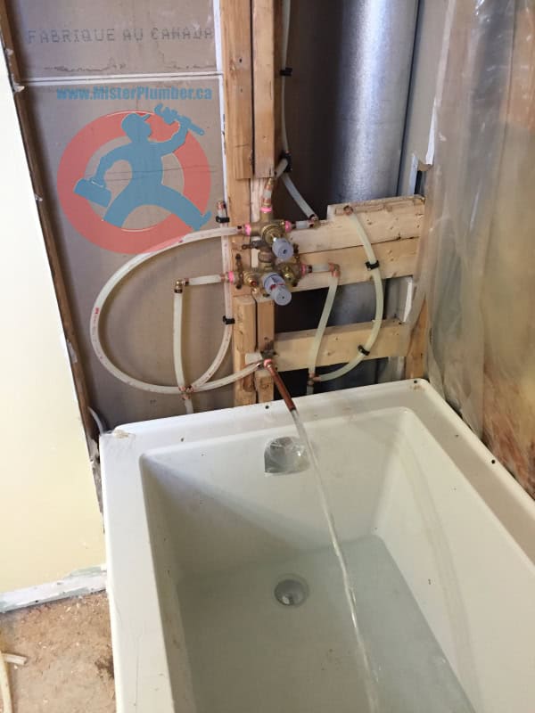 Plumber checks bathtub and faucet after installation