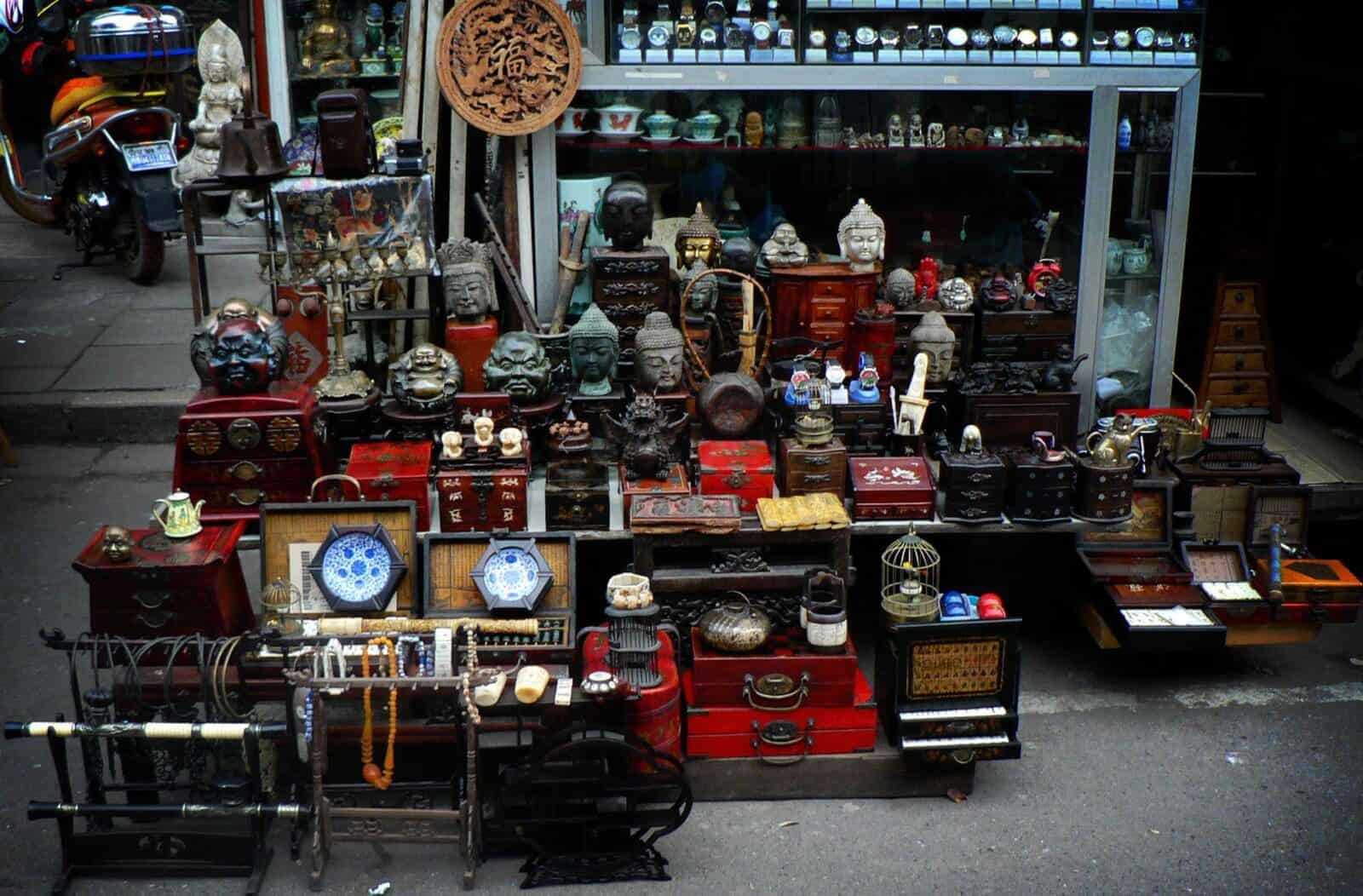 Chinese family and visitor cooking together in a home kitchen with fresh vegetables and wok on the stove