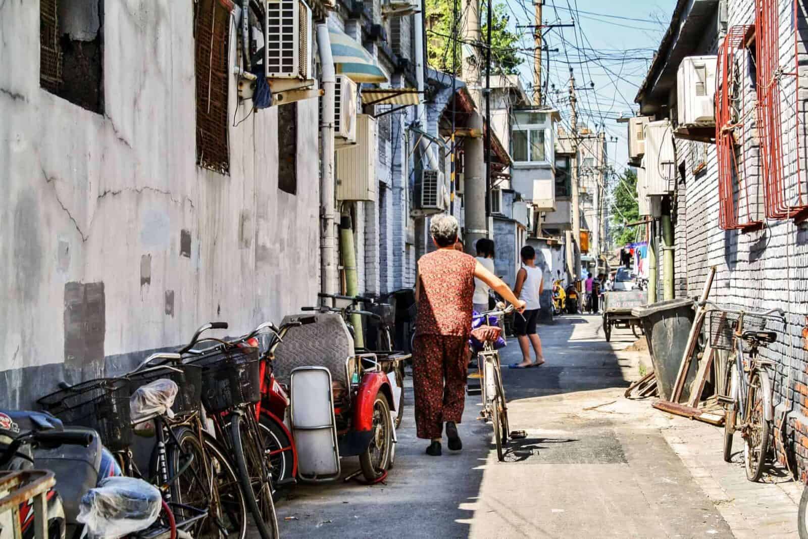 Traditional Beijing hutong alley with bicycles, brick houses and red lanterns near Houhai Lake