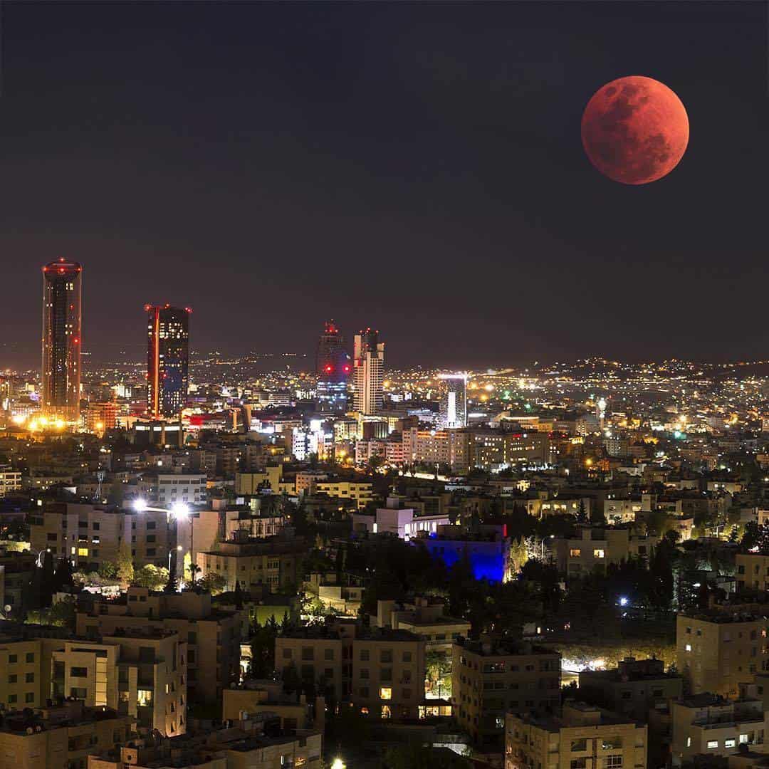 View of Amman city with houses stacked on hillsides under a clear sky