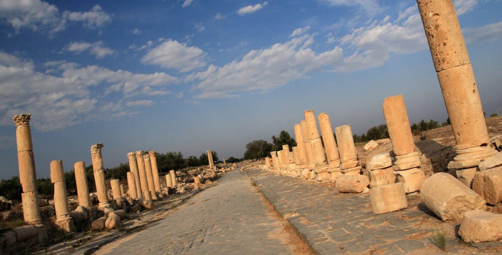 Ancient stone ruins at Umm Qais overlooking green hills and the Sea of Galilee