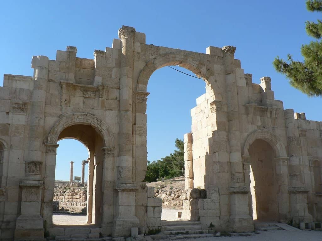 Colonnaded Roman street and ruins in Jerash under a bright blue sky