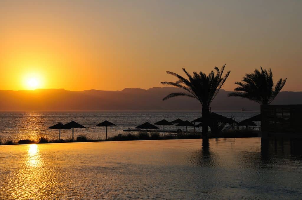 Sandy beach and turquoise waters of the Red Sea near Aqaba with mountains in the background