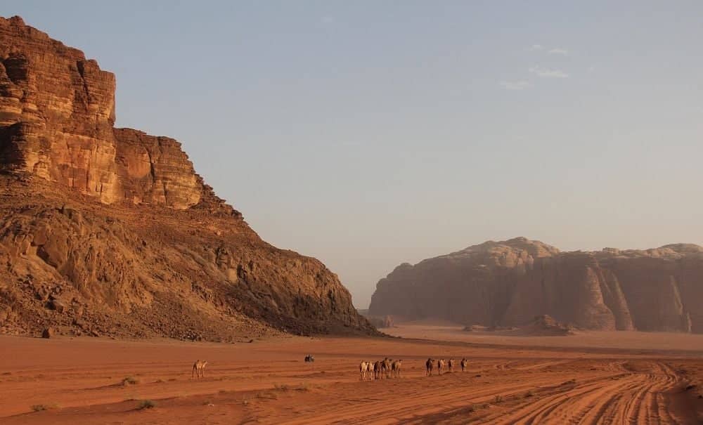 Traveler walking through the narrow Siq canyon towards the Treasury in Petra, Jordan