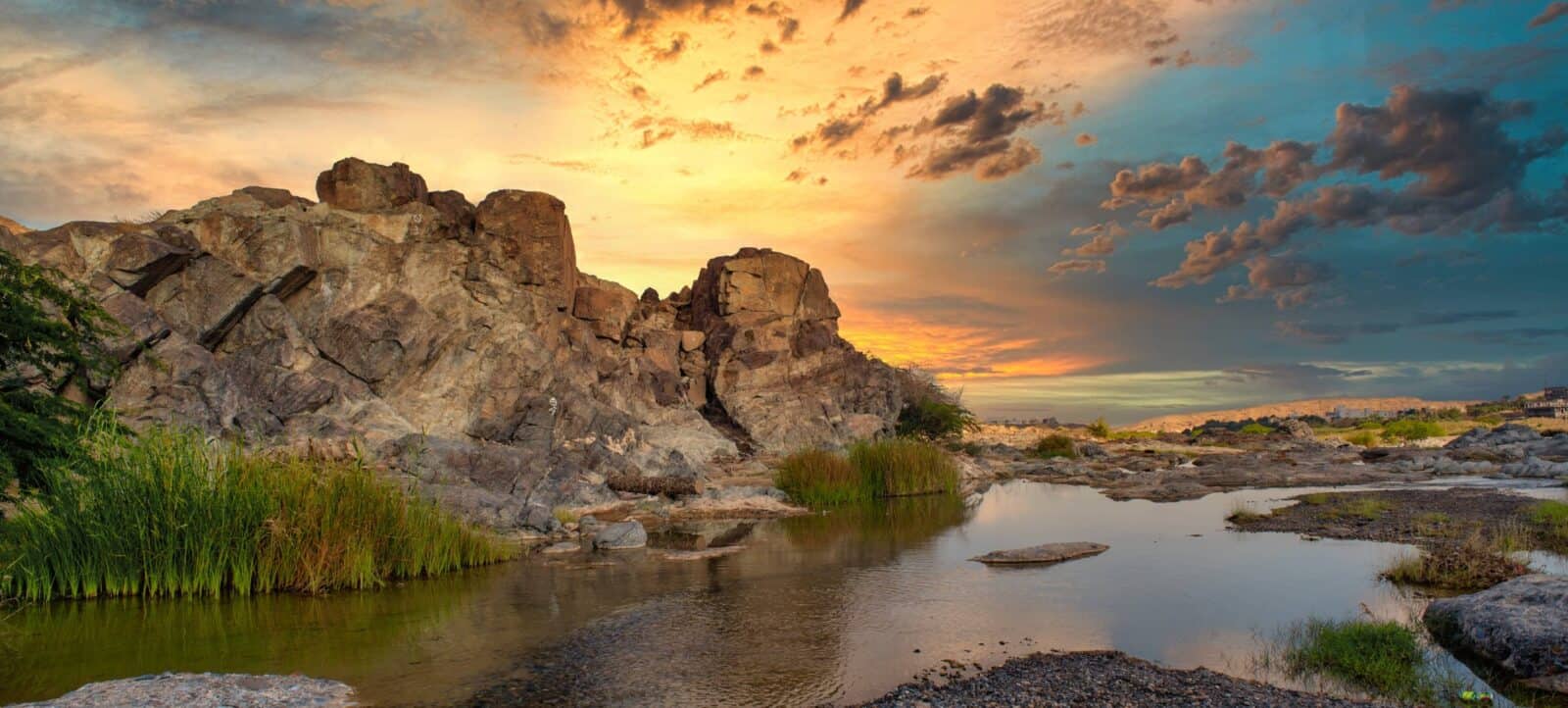Gravel road winding through the dramatic rocky gorge of Wadi Bani Awf in Oman