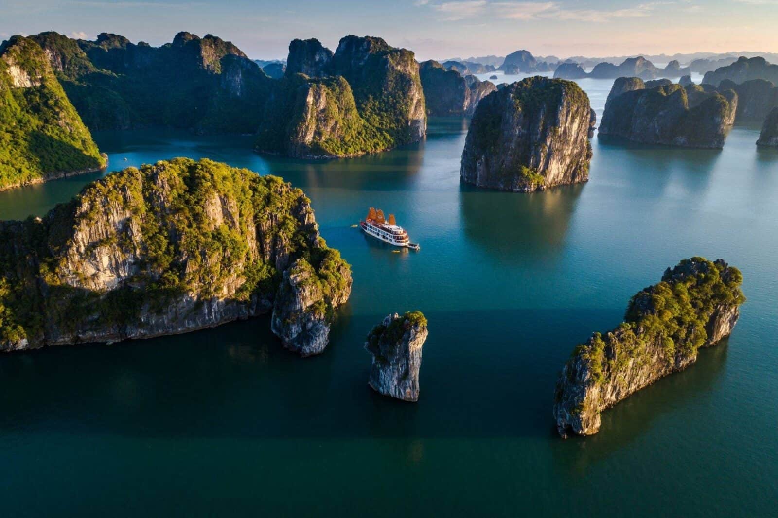Scenic view from a boat of limestone formations at sunrise in Halong Bay, Vietnam
