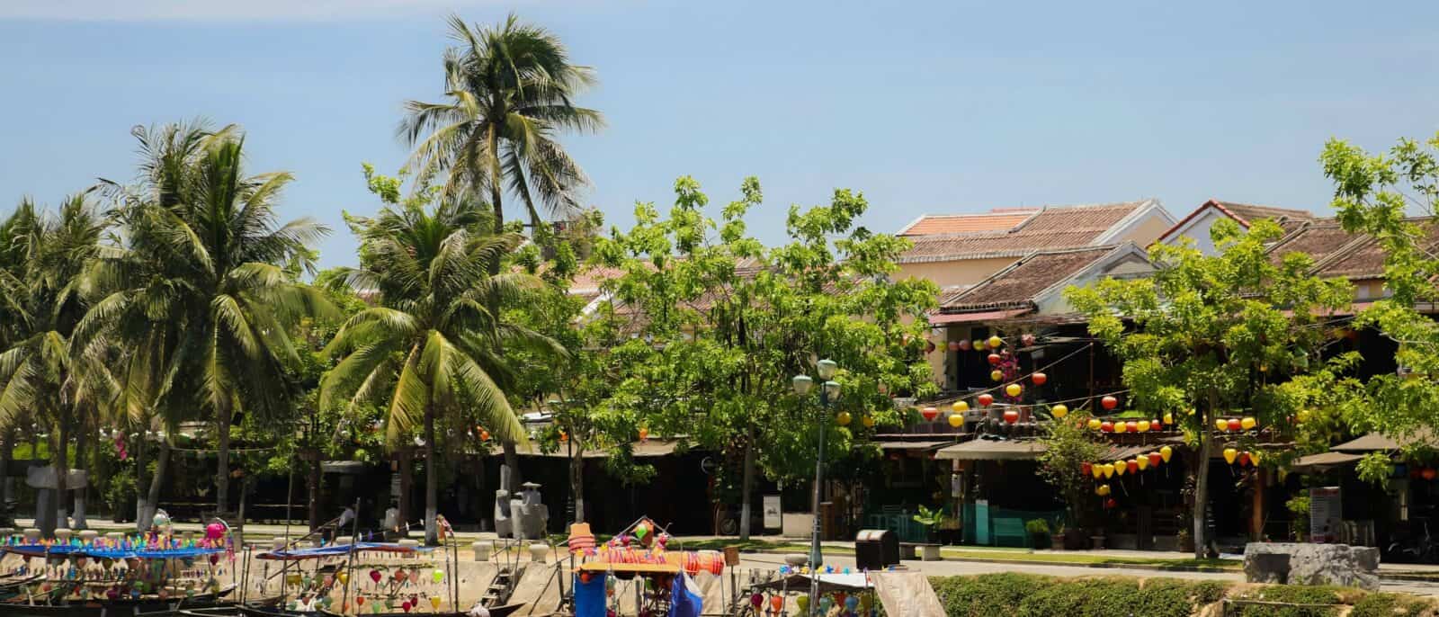 Cruise boat sailing through Ha Long Bay at sunrise with passengers having breakfast on deck