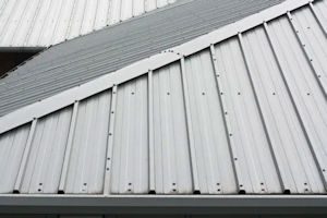 Close-up view of a silver metal roof with exposed fasteners