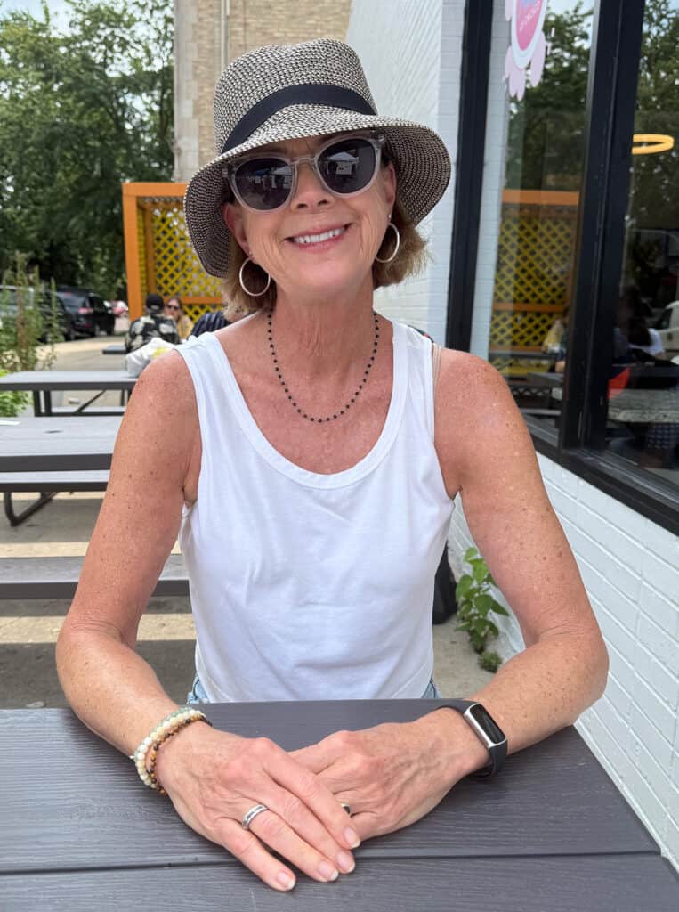 Sara Marberry smiling at camera wearing a straw hat and sunglasses.