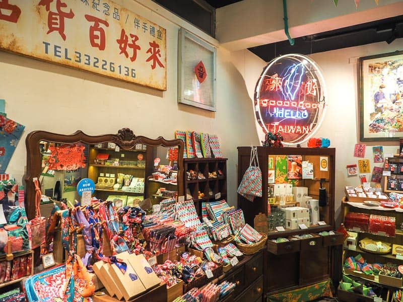 Inside a Taiwanese souvenir shop, with shelves containing multiple types of tourist souvenirs and some traditional signs on the walls