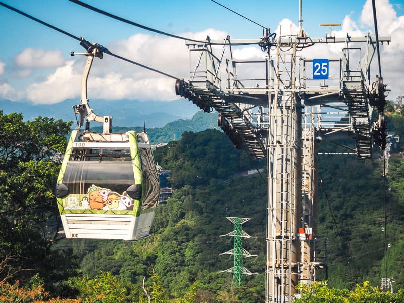 A car of the Maokong Gondola passing by a tall pole