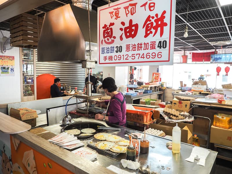 A green onion cake vendor in a traditional market