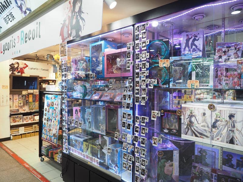 Front of a shop with glass displays containing many toy models and otaku products
