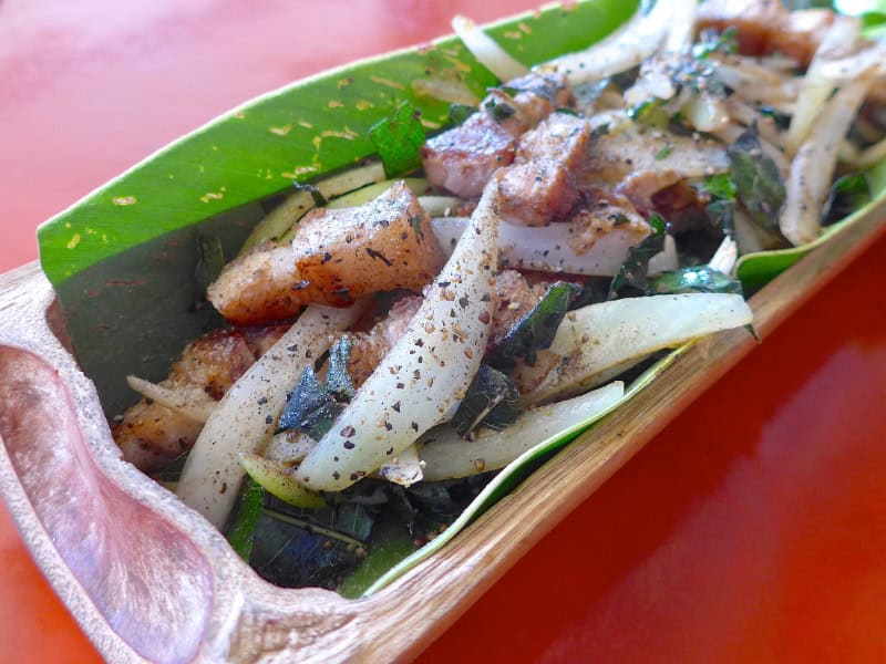 Close up of an aboriginal Taiwanese dish, which is chunks of fried pork and onion served in a bamboo tube